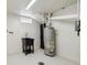 A practical basement utility space showcasing a water heater, laundry hookups, and a sink at 7833 Raritan St, Denver, CO 80221