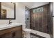 This is a remodeled bathroom featuring a mosaic tiled shower with black accents, a modern vanity, and patterned flooring at 7833 Raritan St, Denver, CO 80221