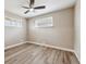 A simplistic bedroom featuring wood-look flooring, neutral walls, baseboard trim and bright, sunlit windows at 7833 Raritan St, Denver, CO 80221