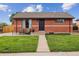 Charming brick home with manicured lawn, front seating, and attractive curb appeal at 7833 Raritan St, Denver, CO 80221