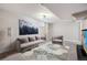 An inviting living room featuring a plush grey couch, an accent rug, and bright, overhead lighting at 7833 Raritan St, Denver, CO 80221