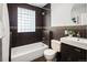 Cozy bathroom featuring dark tile, glass block window, and modern fixtures including a dark vanity at 3743 N Yates St, Denver, CO 80212