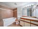 A bathroom featuring brown tile, a shower-tub combo, and a vanity with a white countertop at 6380 Oak St # 107, Arvada, CO 80004