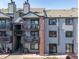 Exterior view of multi-level apartments showing decks, stairwells, and an A/C unit at 6380 Oak St # 107, Arvada, CO 80004
