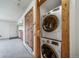 Laundry closet featuring a stackable washer and dryer, as well as a wooden door at 6380 Oak St # 107, Arvada, CO 80004