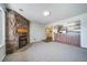 Bright open-concept living room with a stone fireplace and seamless flow into the kitchen area at 6380 Oak St # 107, Arvada, CO 80004