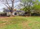 Large backyard featuring mature trees, grass, wood deck, and a firepit, perfect for outdoor entertaining and relaxation at 10862 Albion Dr, Thornton, CO 80233