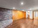Finished basement features wood paneling, brick accents, durable flooring, and stairway to the upper level at 10862 Albion Dr, Thornton, CO 80233