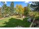 Lush green backyard with mature trees and landscaping offering a serene and private outdoor space at 4 Arabian Pl, Littleton, CO 80123