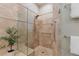 Luxurious walk-in shower featuring travertine tile, a glass enclosure, and sleek chrome fixtures at 4 Arabian Pl, Littleton, CO 80123