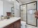 Modern bathroom featuring a glass-enclosed shower, dark fixtures, and decorative tile accents at 10553 Fairhurst Way, Highlands Ranch, CO 80126