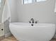 Close-up of a modern, freestanding soaking tub with sleek black fixtures and bright natural light at 10553 Fairhurst Way, Highlands Ranch, CO 80126