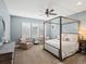 Primary bedroom featuring large windows, a four-poster bed, and neutral-toned decor at 10553 Fairhurst Way, Highlands Ranch, CO 80126