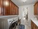 Laundry room with front-load washer and dryer, ample cabinet space, and access to the bedroom and closet at 10553 Fairhurst Way, Highlands Ranch, CO 80126
