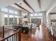 Open-concept living area featuring hardwood floors, exposed beams, many windows, and a fireplace at 10553 Fairhurst Way, Highlands Ranch, CO 80126
