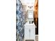 This modern bathroom features a white vanity, a decorative shower curtain, and a rustic wood accent wall at 12175 Birch St, Thornton, CO 80241