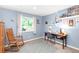 Bedroom with light blue walls, desk, storage, rocking chair, and a bright window creates a versatile space at 12175 Birch St, Thornton, CO 80241