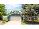 Charming blue home with a two-car garage, mature trees, and a red front door at 12175 Birch St, Thornton, CO 80241
