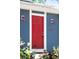 Close-up of a bright red front door with vintage outdoor lighting sconces on a blue-sided home at 12175 Birch St, Thornton, CO 80241