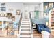 Staircase with black railings leading to the open living room with stylish decor and wood floors at 12175 Birch St, Thornton, CO 80241