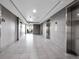 Modern hallway with tile floor leading to elevators and glass doors at 891 14Th Street # 1712, Denver, CO 80202