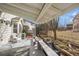 Backyard covered patio with gray wood and a view to the white fenced yard and adjacent property at 13649 Plaster Cir, Broomfield, CO 80023
