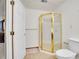 Bathroom features a standing shower with a gold trim and fixtures, with tile floor and white walls at 13649 Plaster Cir, Broomfield, CO 80023