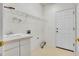 Simple laundry room featuring a utility sink, metal shelving, tile floor, and exterior access at 13649 Plaster Cir, Broomfield, CO 80023