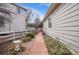 Features a red walkway through the side yard to the backyard with wooden white fencing at 13649 Plaster Cir, Broomfield, CO 80023