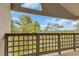 View from balcony with wood railing overlooks mature trees and blue sky at 1000 E 1St Ave # 405, Denver, CO 80218