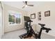 Bright home gym features a Peloton bike, ceiling fan and a window with natural light at 5745 S Buchanan Ct # C, Aurora, CO 80016