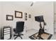 Bright home gym features a Peloton bike, desk, ceiling fan and decor at 5745 S Buchanan Ct # C, Aurora, CO 80016