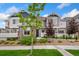 Charming townhouse showcasing a well-manicured lawn, stone accents, and appealing architectural details under a bright sky at 5745 S Buchanan Ct # C, Aurora, CO 80016