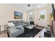 Inviting living room features a comfortable gray couch, a sleek glass table, and ample natural light from the front door at 5745 S Buchanan Ct # C, Aurora, CO 80016