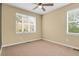 Neutral carpeted bedroom featuring dual windows allowing natural light to fill the space at 8260 E 24Th Dr, Denver, CO 80238