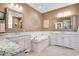 Spa-like bathroom with double vanities, a soaking tub, and granite counters at 5960 S Watson Ln, Littleton, CO 80123