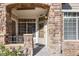 Inviting entryway with stone arch, a wreath, and a small bench at 12711 Colorado Blvd # 912, Thornton, CO 80241