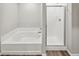 Elegant bathroom featuring a modern tub and separate shower with glass doors at 2175 Alyssa St, Fort Lupton, CO 80621