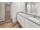 Bright bathroom featuring double vanity, granite countertop, and a view to the walk-in closet at 2175 Alyssa St, Fort Lupton, CO 80621