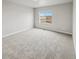 A spacious bedroom with light gray walls, plush carpeting, and a window offering a scenic view at 2175 Alyssa St, Fort Lupton, CO 80621