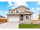 Charming two-story home featuring a two-car garage, light brown siding, and a well-maintained front lawn at 2175 Alyssa St, Fort Lupton, CO 80621