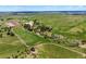 Vast aerial of the property features sprawling green pastures, mature trees, and riding facilities at 2470 Driftwood, Elizabeth, CO 80107