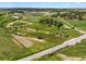 Drone eye view features the property with green fields, a pond, mature trees, and a road nearby at 2470 Driftwood, Elizabeth, CO 80107
