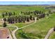 Scenic aerial view with green meadows, winding roads, groupings of trees, and equestrian facilities at 2470 Driftwood, Elizabeth, CO 80107
