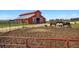 Exterior view of a red barn with horses in a pen at 2470 Driftwood, Elizabeth, CO 80107