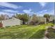 Lush backyard with a large lawn, mature trees, and a detached garage at 15976 E Radcliff Pl # A, Aurora, CO 80015