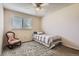 Cozy bedroom featuring a twin bed, a rocking chair, and a window with natural light at 15976 E Radcliff Pl # A, Aurora, CO 80015