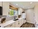 Updated kitchen featuring white cabinets, modern appliances, and a window with natural light at 15976 E Radcliff Pl # A, Aurora, CO 80015