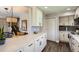Open kitchen features lots of quartz countertops, white cabinets, and stainless appliances at 15976 E Radcliff Pl # A, Aurora, CO 80015