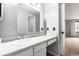 Bright bathroom featuring a white vanity and a mirror cabinet, next to a door way to the shower at 401 S Kalispell Way # 104, Aurora, CO 80017
